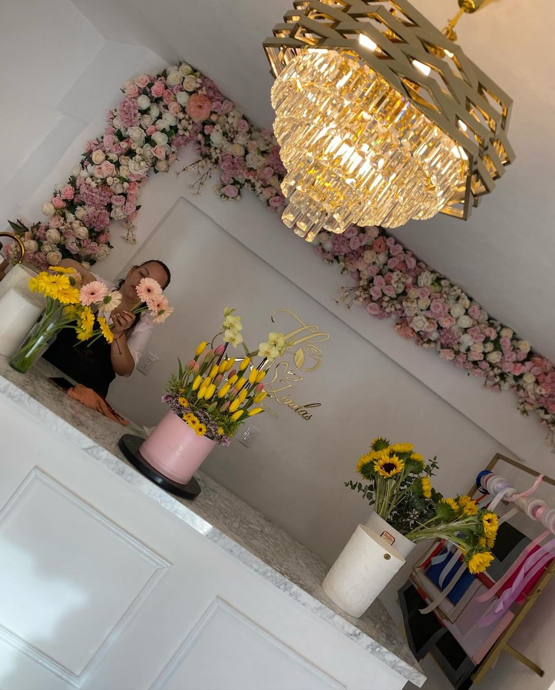 Mostrador de Lindas con candelabro de cristal, muro floral y flores frescas